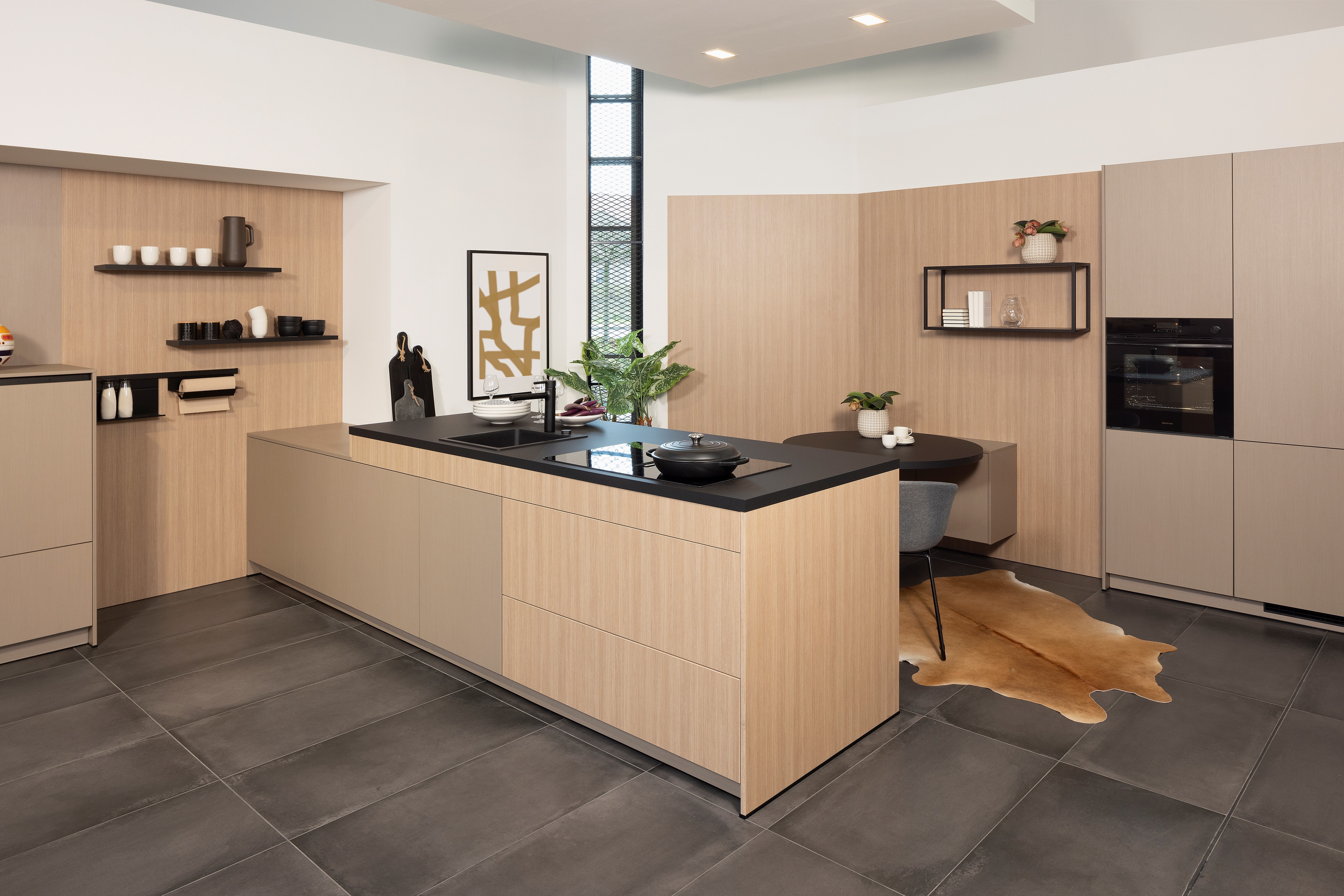 APL: Samtschwarz Front: Line Eiche liniert Front: INOX Light brushed Korpus: Graphit Griff: Grifflos Schwarz Geräte: Constructa Armatur: Franke Spüle: Franke  Features: eine der ersten Küchenfronten in neuer Farbe (Walze von damals), Nischenverkleidung Eiche liniert, Samtschwarze APL, Living (kleiner Sitzplatz mit Regal), Materialmix, Korpus in Graphit.