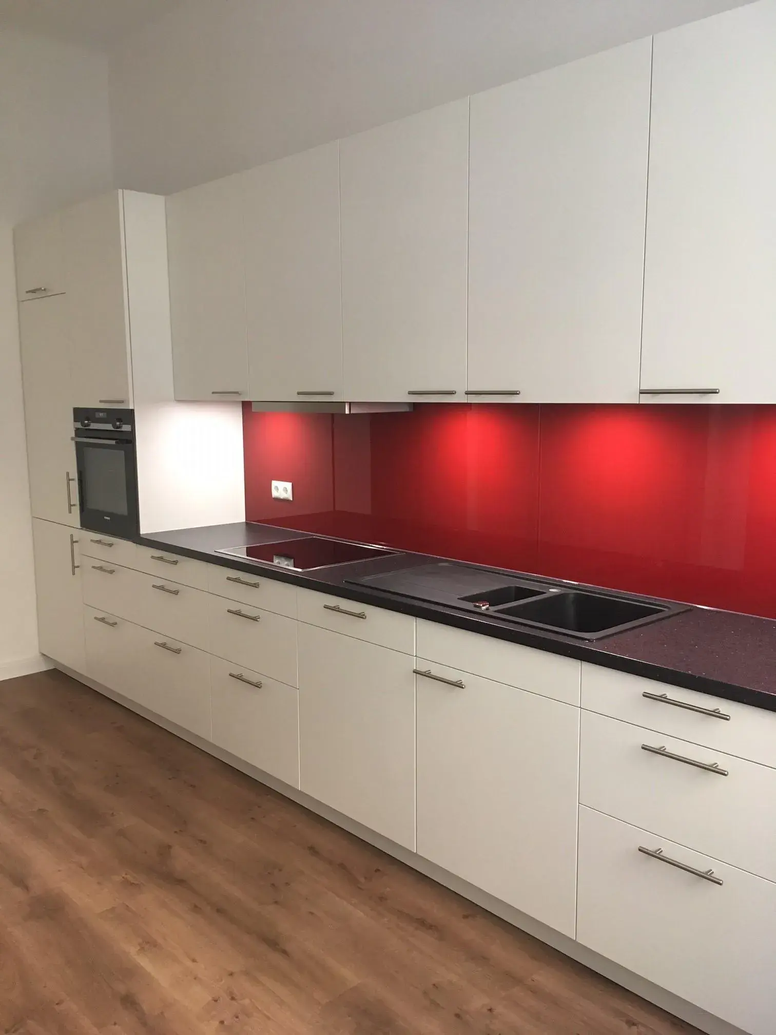 Küchenzeile weiß mit Nischenrückwand rot glänzend und Arbeitsplatte anthrazit
